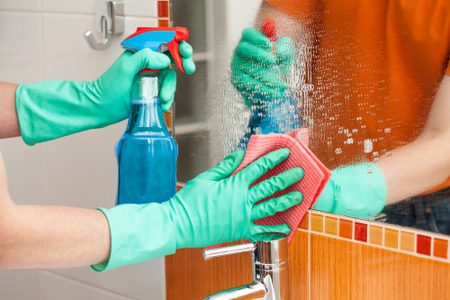 Cleaner handling labelled cleaning chemicals safely